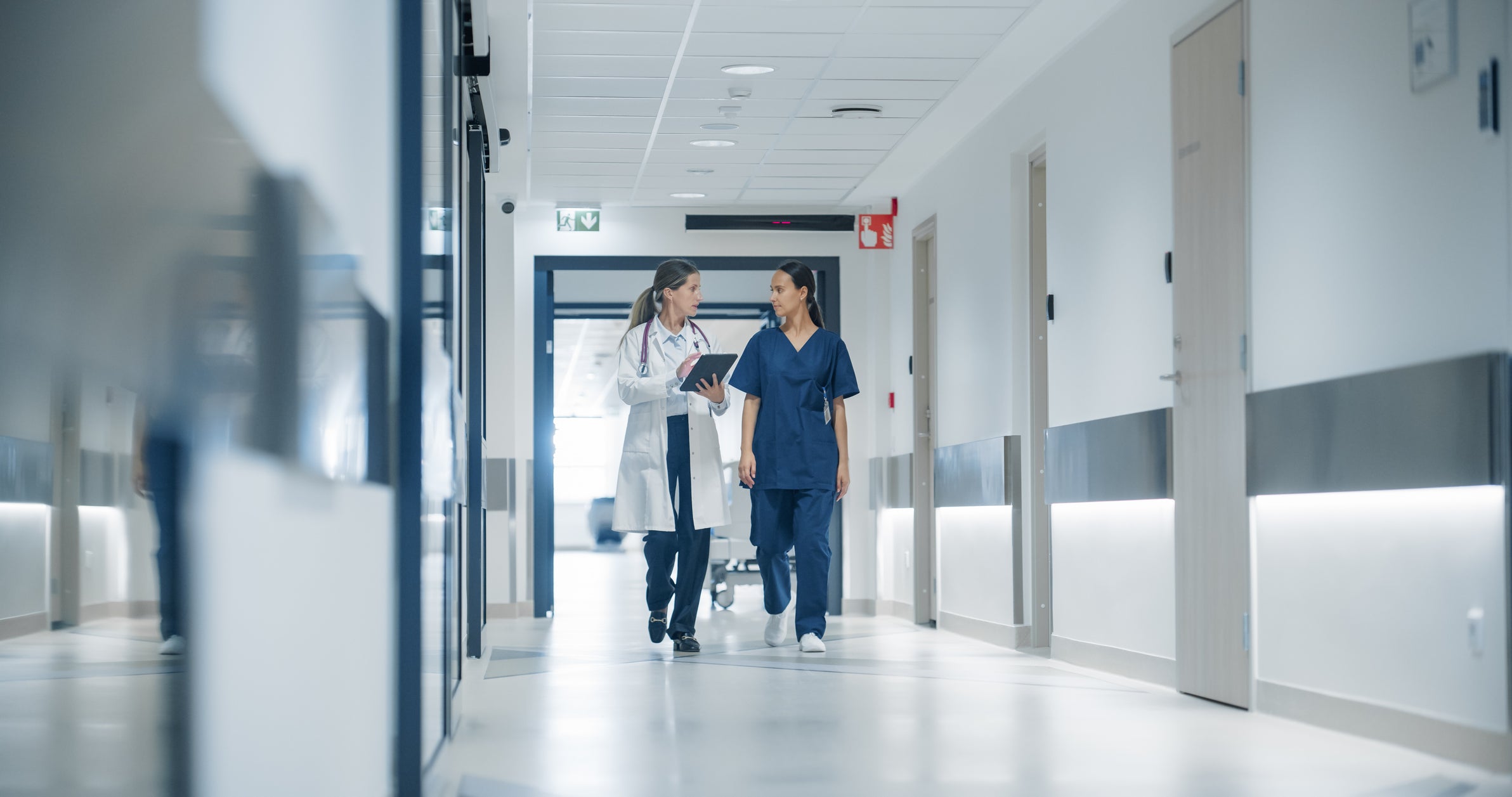 Healthcare professionals walking on anti-slip hospital flooring – ideal for Stellmann Non-Slip Clear to reduce patient injury risk and meet compliance