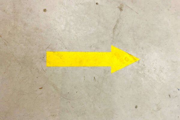 Why Line Marking for Warehouses Is a Must in 2026: yellow directional arrow on warehouse floor