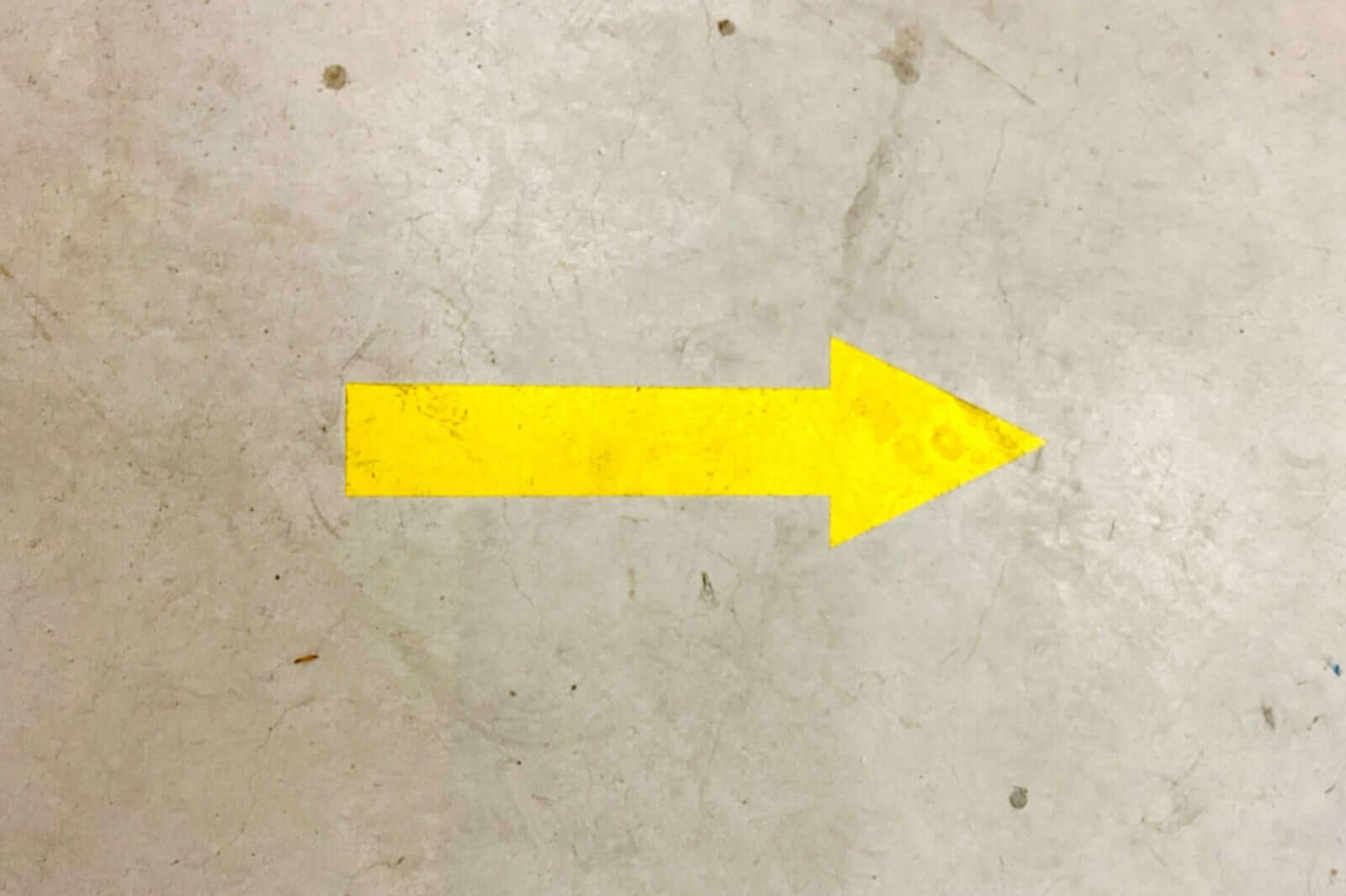 Why Line Marking for Warehouses Is a Must in 2026: yellow directional arrow on warehouse floor