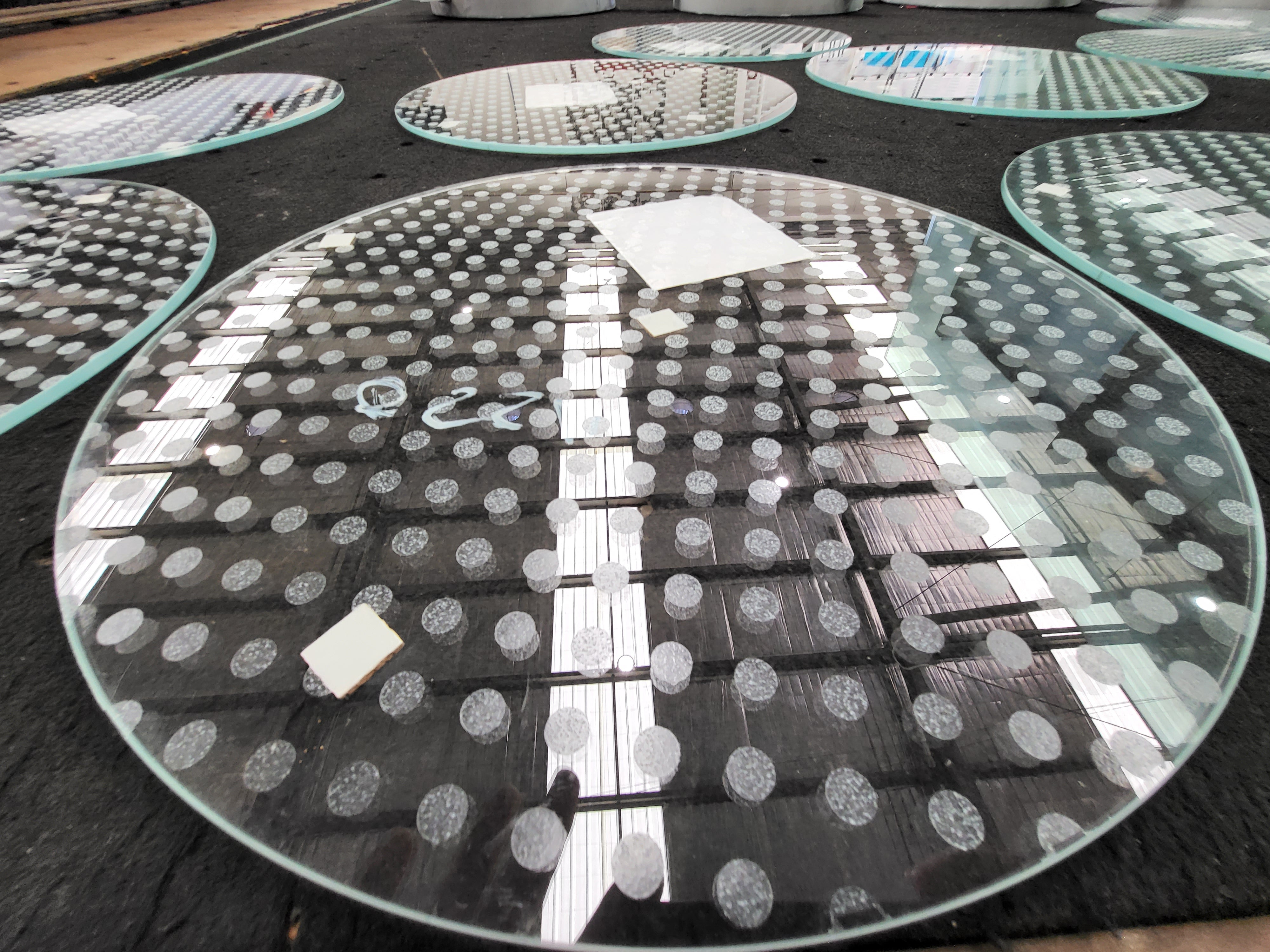 Circular glass panels with factory-applied anti-slip dot matrix pattern – compliant with AS 4586 slip rating for commercial flooring and architectural glazing