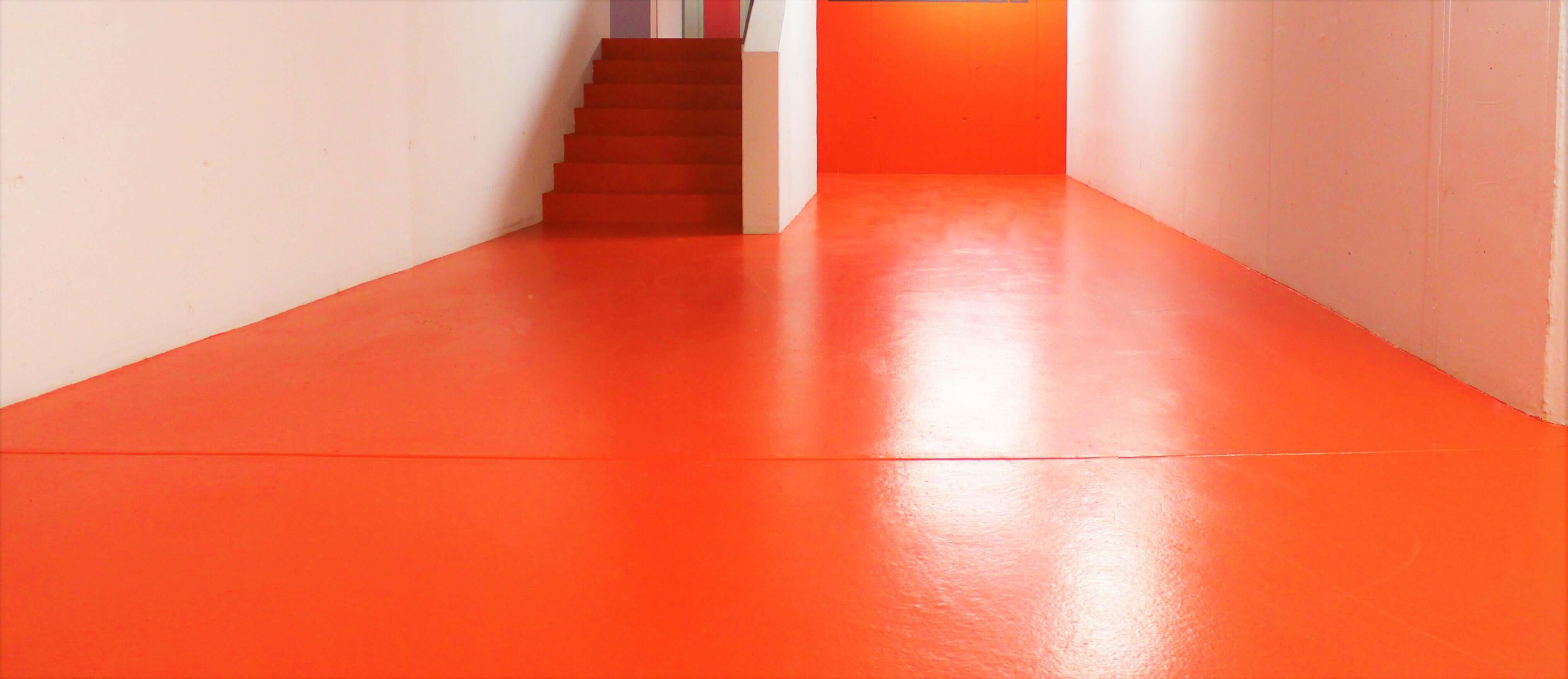 Indoor commercial space with bright red Stellmann non-slip coating for safety and visual demarcation in wet areas