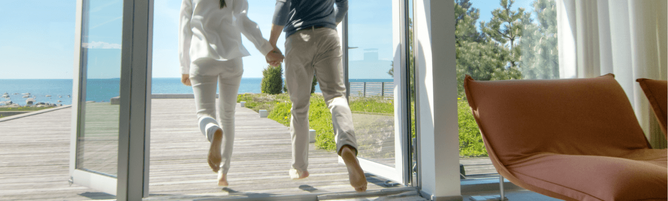 Couple stepping barefoot from interior onto outdoor decking treated with Stellmann clear anti‑slip coating—providing seamless, safe transitions without compromising aesthetics.