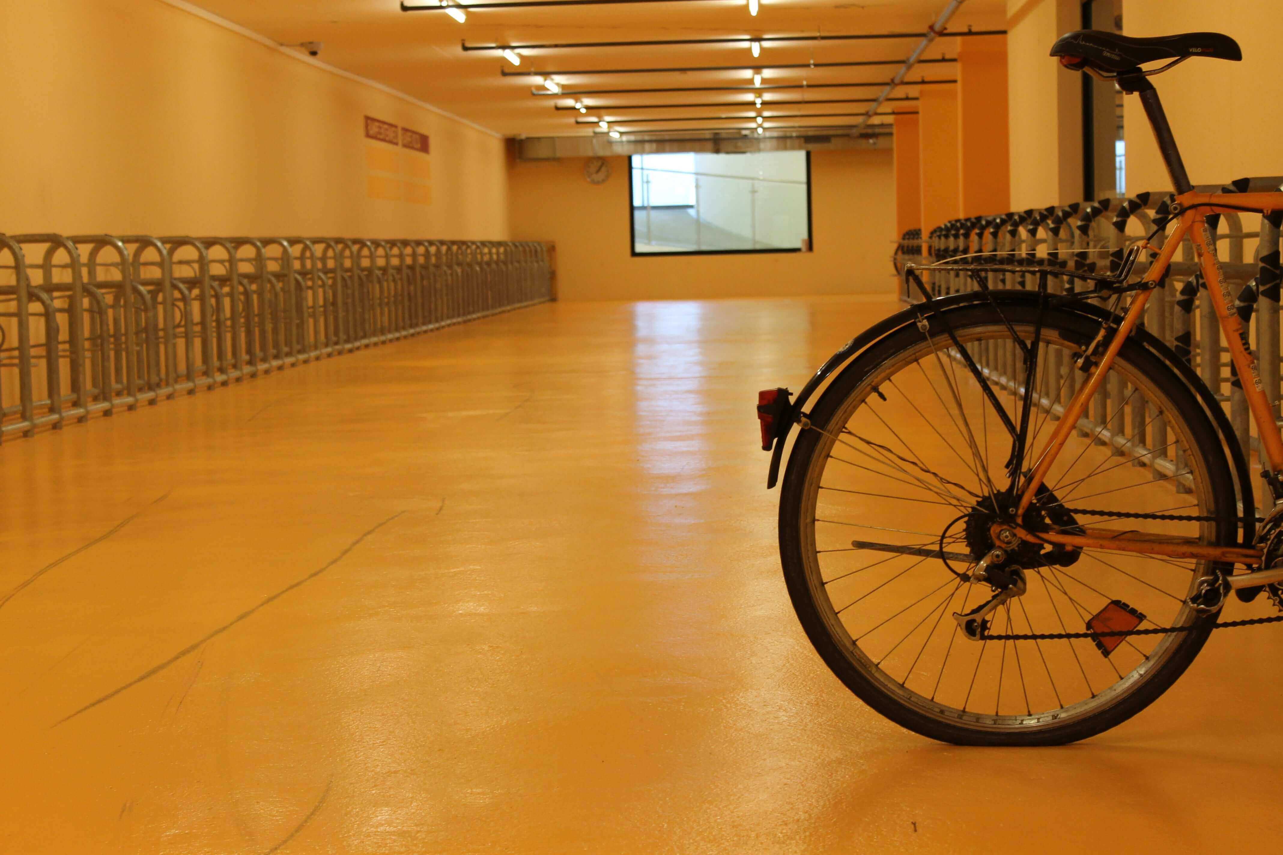 Bright yellow Stellmann non-slip coating applied to indoor bicycle parking zone, enhancing safety and visibility