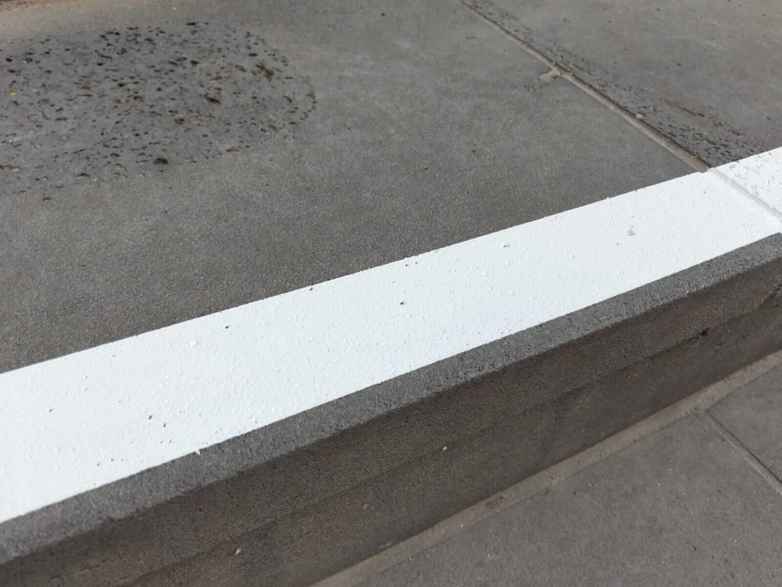 Outdoor steps coated with grey slip-resistant surface and white Stellmann non-slip nosing for contrast and fall prevention